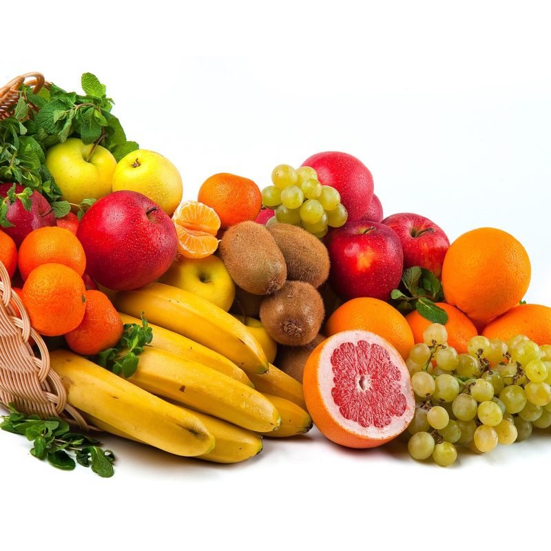 Composition with vegetables and fruits in wicker basket isolated on white